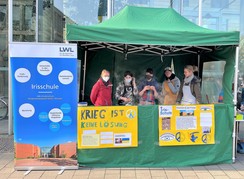Foto des Pavillons mit Schüler:innen, Lehrer:innen und Plakaten