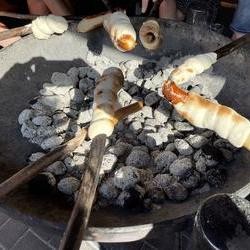 Foto: Feuerschale mit Stockbrot darüber (vergrößerte Bildansicht wird geöffnet)