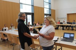 Foto von Katja Hemmers und Elisabeth Hordt bei ihrer Ehrung vor dem Kollegium