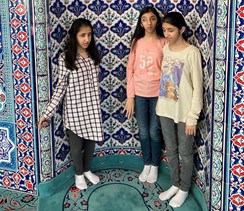 Foto drei Schülerinnen stehen in der Gebetsnische in der Moschee