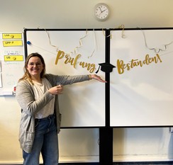 Foto von Marieke Langenfurth am Whiteboard  mit dem Schriftzug "Prüfung bestanden"