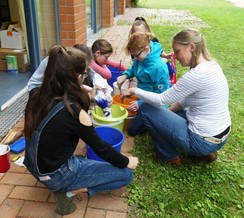 Foto der Gruppe beim Batiken an den Farbeimern