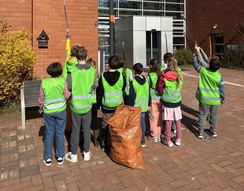 Foto der Primarstufenklasse 2 mit Warnwesten und Müllzangen