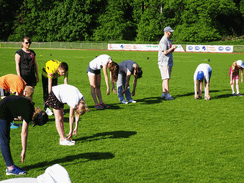 Foto von einigen Schülerinnen und Schülern bei der Erwärmung auf dem Sportplatz