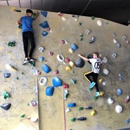 Foto von Lennart und Mohamed an der Boulderwand (vergrößerte Bildansicht wird geöffnet)