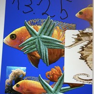 Ein Bild ist auf einem iPad abgebildet. Vor einem blauen Hintergrund sind Goldfische, Seesterne, Korallen und ein Seepferdchen abgebildet. (vergrößerte Bildansicht wird geöffnet)