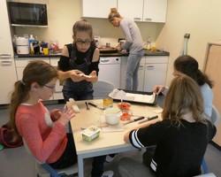 Foto der Gruppe bei der Essensvorbereitung (vergrößerte Bildansicht wird geöffnet)