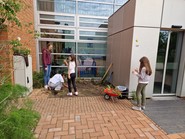 Foto von Schülerinnen die an einem Blumenbeet arbeiten (vergrößerte Bildansicht wird geöffnet)