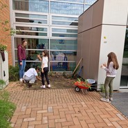 Foto von Schülerinnen die an einem Blumenbeet arbeiten (vergrößerte Bildansicht wird geöffnet)