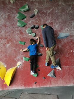 Foto von Herr Nagel, wir er Yasin an der Boulderwand Tipps gibt (vergrößerte Bildansicht wird geöffnet)