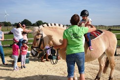 Foto vom Pferd Helli mit FF-Kind auf dem Rücken und Lehrerin an der Seite