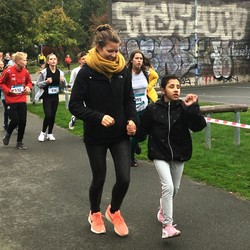 Foto von einer blinen Schülerin mit Begleitläuferin und weiteren Läufern (vergrößerte Bildansicht wird geöffnet)