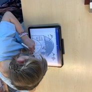 Eine Schülerin sitzt vor ihrem iPad, auf dem sie mit ihrem Apple Pencil ein Haus zeichnet. (vergrößerte Bildansicht wird geöffnet)