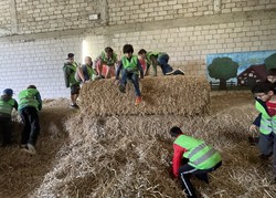 Foto der Gruppe in der Strohscheune, einige springen von den Strohballen (vergrößerte Bildansicht wird geöffnet)