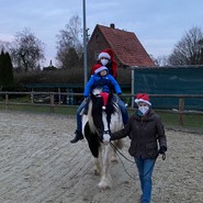 Foto vom geführtem Pferd mit reitendem Kind (vergrößerte Bildansicht wird geöffnet)