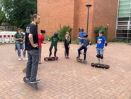 Foto von Schüler:innen beim Skaten auf dem Schulhof (vergrößerte Bildansicht wird geöffnet)