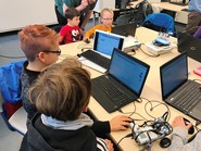 Foto von Schülern am Laptop beim Programmieren ihres Roboters (vergrößerte Bildansicht wird geöffnet)