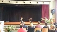 Foto von zwei ehemaligen Schülerinnen bei der Präsentation eines Stückes aus Wicked (vergrößerte Bildansicht wird geöffnet)