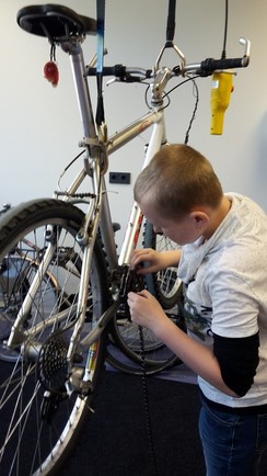 Foto von einem blinden Schüler, der ein Fahrrad repariert