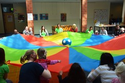 Foto von Teilnehmern bei Schwungtuchspielen in der Aula