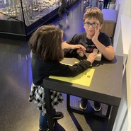 Foto von Schüler:innen bei den Ammoniten (vergrößerte Bildansicht wird geöffnet)