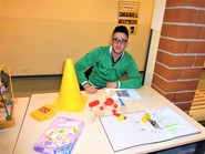 Foto eines Schülers bei der Praktikumspräsentation an der Irisschule an seinem Präsentationstisch mit Materialien aus dem Praktikum (vergrößerte Bildansicht wird geöffnet)