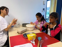 Foto: Alisha, Ansam und Vida mischen den Teig für den Kartoffelkuchen (vergrößerte Bildansicht wird geöffnet)