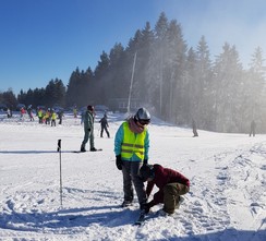 Foto von Frau Schettler und Azra beim Anziehen eines Skis