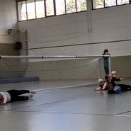 Lara, Pia und José liegen in Abwehrhaltung vor dem Tor und Pia wehrt einen Goalball ab. (vergrößerte Bildansicht wird geöffnet)