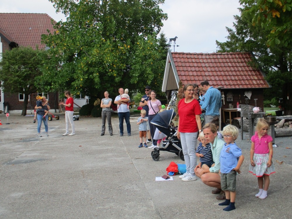 Foto mit den Kindern, Eltern und Lehrkräfte. Alle stehen zusammen in einem großen Halbkreis auf dem Hof. auf