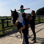 Foto von einem Kind auf einem Pferd mit ausgebreiteten Armen (vergrößerte Bildansicht wird geöffnet)
