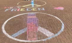 Foto der Kreidezeichnung auf dem Schulhof mit Peace-Zeichen, Schriftzug "Weltfrieden" und einem Herz