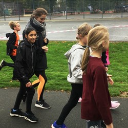 Foto von einer blinen Schülerin mit Begleitläuferin und weiteren Läufern (vergrößerte Bildansicht wird geöffnet)