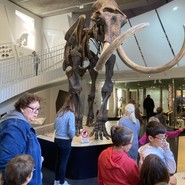 Foto der Gruppe in der Halle mit dem Ahlener Mammut (vergrößerte Bildansicht wird geöffnet)