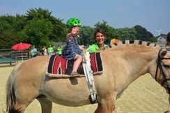 Foto von einem Frühförderkind auf einem Pferd mit Frau Eikel