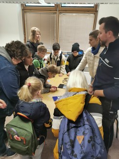 Foto der Gruppe an einem Tisch mit Stempelkissen und Fußfesseln