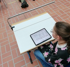 Foto von Maja mit ihrem Lesetext am Tablet